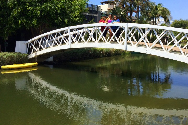 3 women standing on a bridge.