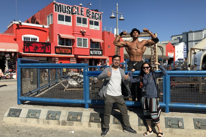 2 people standing in front of muscle beach.